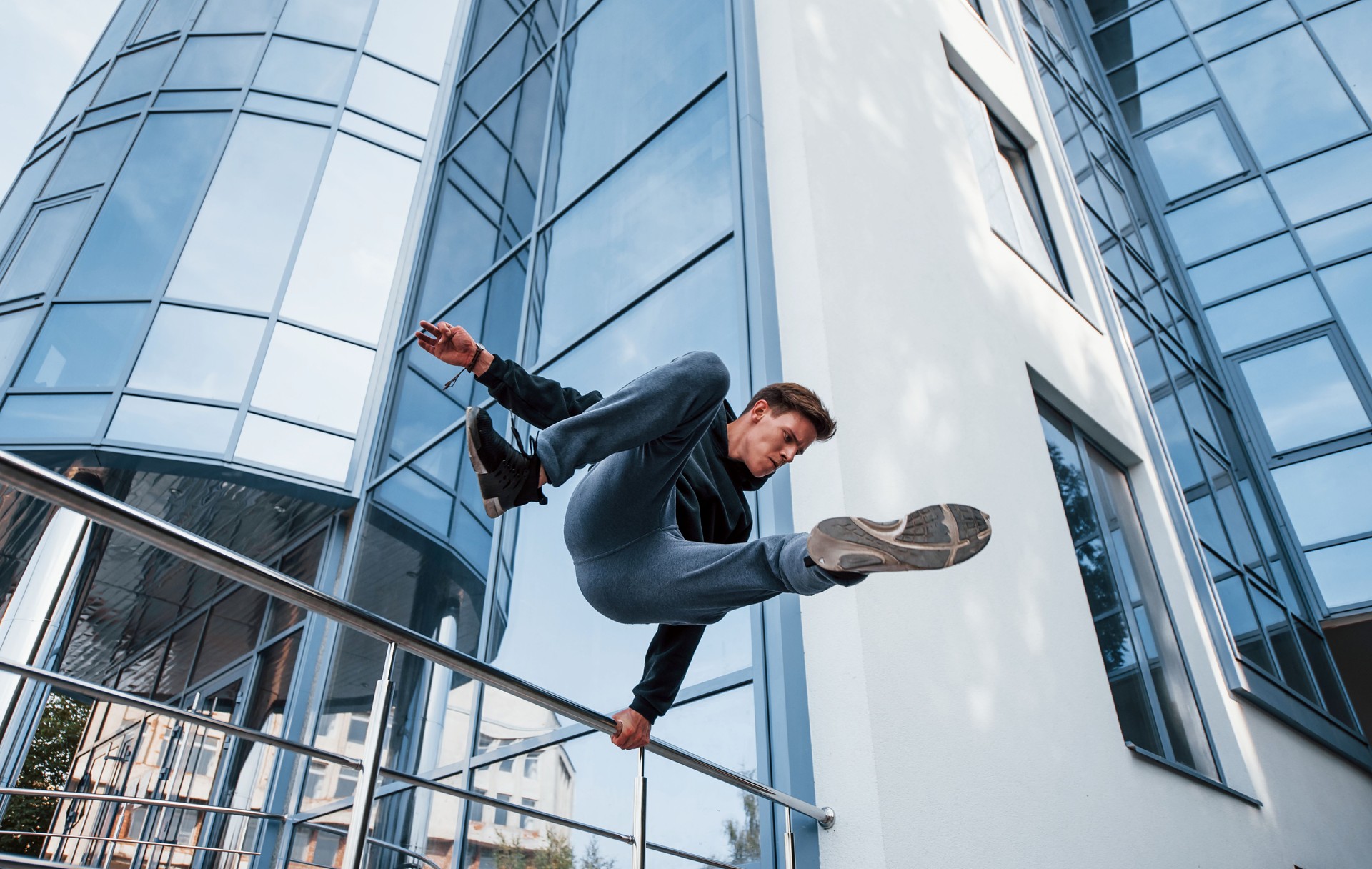 Young man doing parkour in the city at daytime. Conception of extreme sports