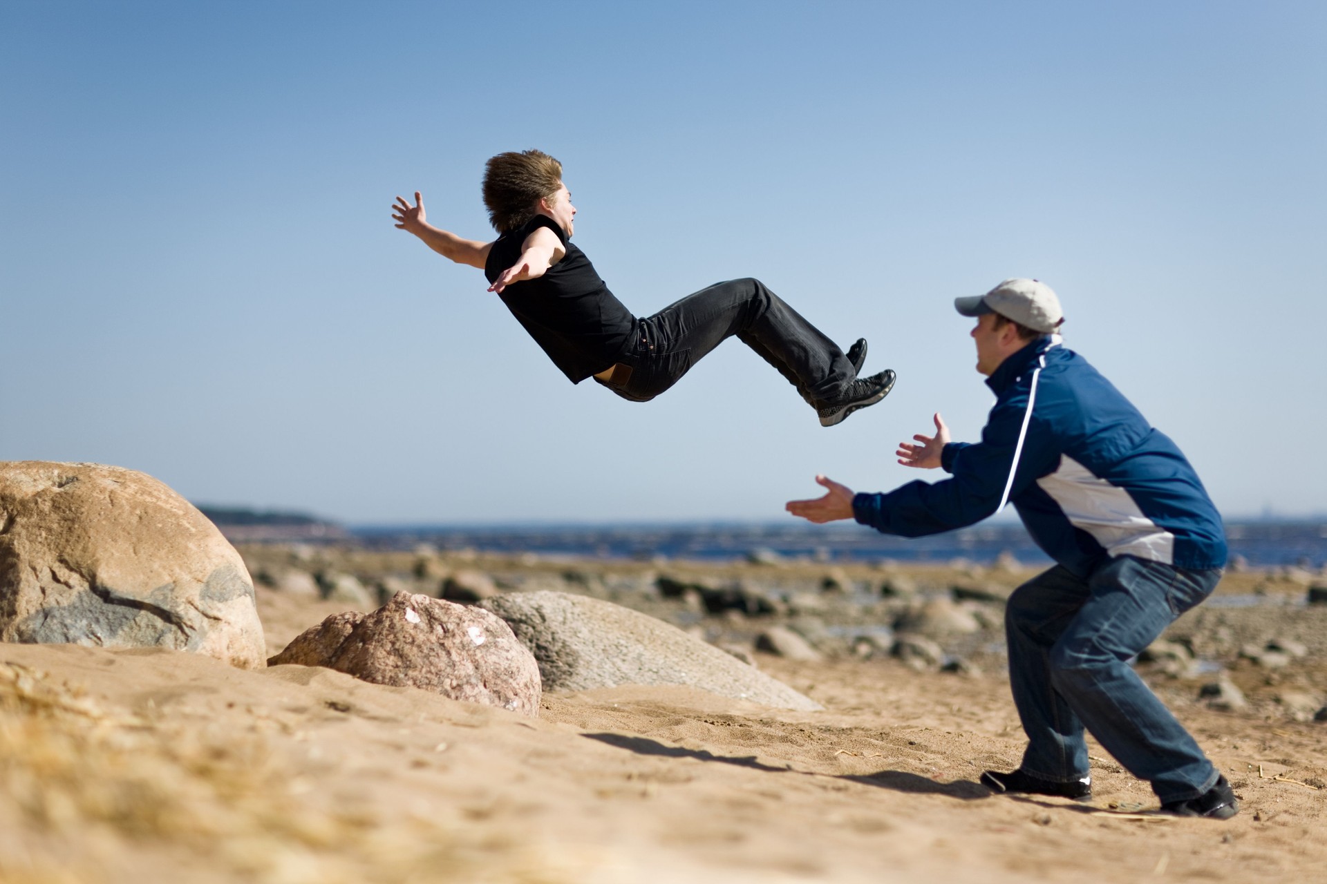 To secure young man when makes extreme jump-overturn over stones.